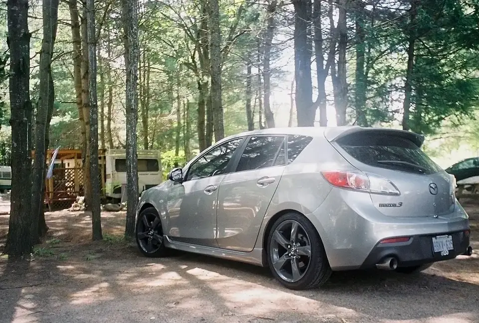Silver Mazda hatchback With Gunmetal Grey Wheels